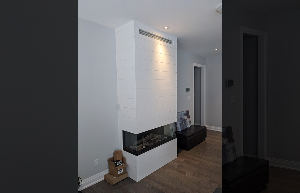 Contemporary three-sided white shiplap gas fireplace in finished home