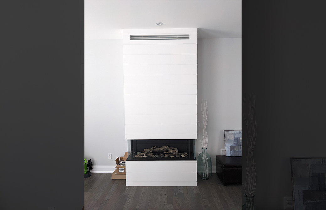 Floor-to-ceiling white shiplap three-sided gas fireplace installation