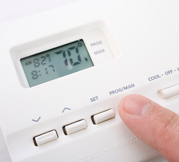 Programmable thermostat being set for efficient HVAC operation