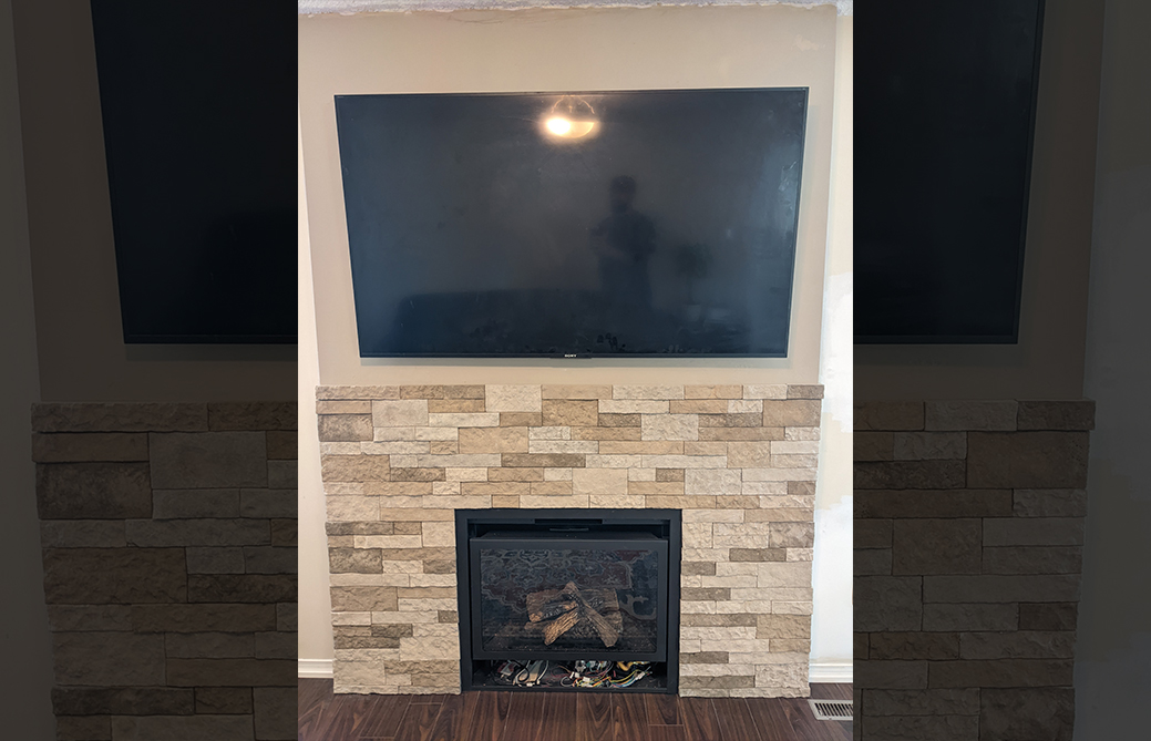 Beige stacked stone gas fireplace with mounted TV in Barrie home