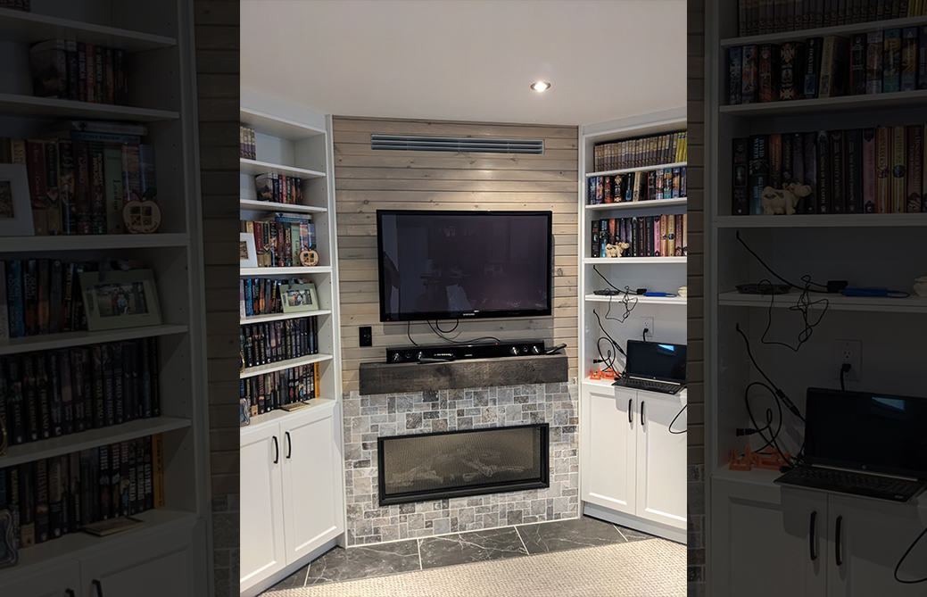 Built-in stone gas fireplace with bookshelves and mounted TV in Barrie home